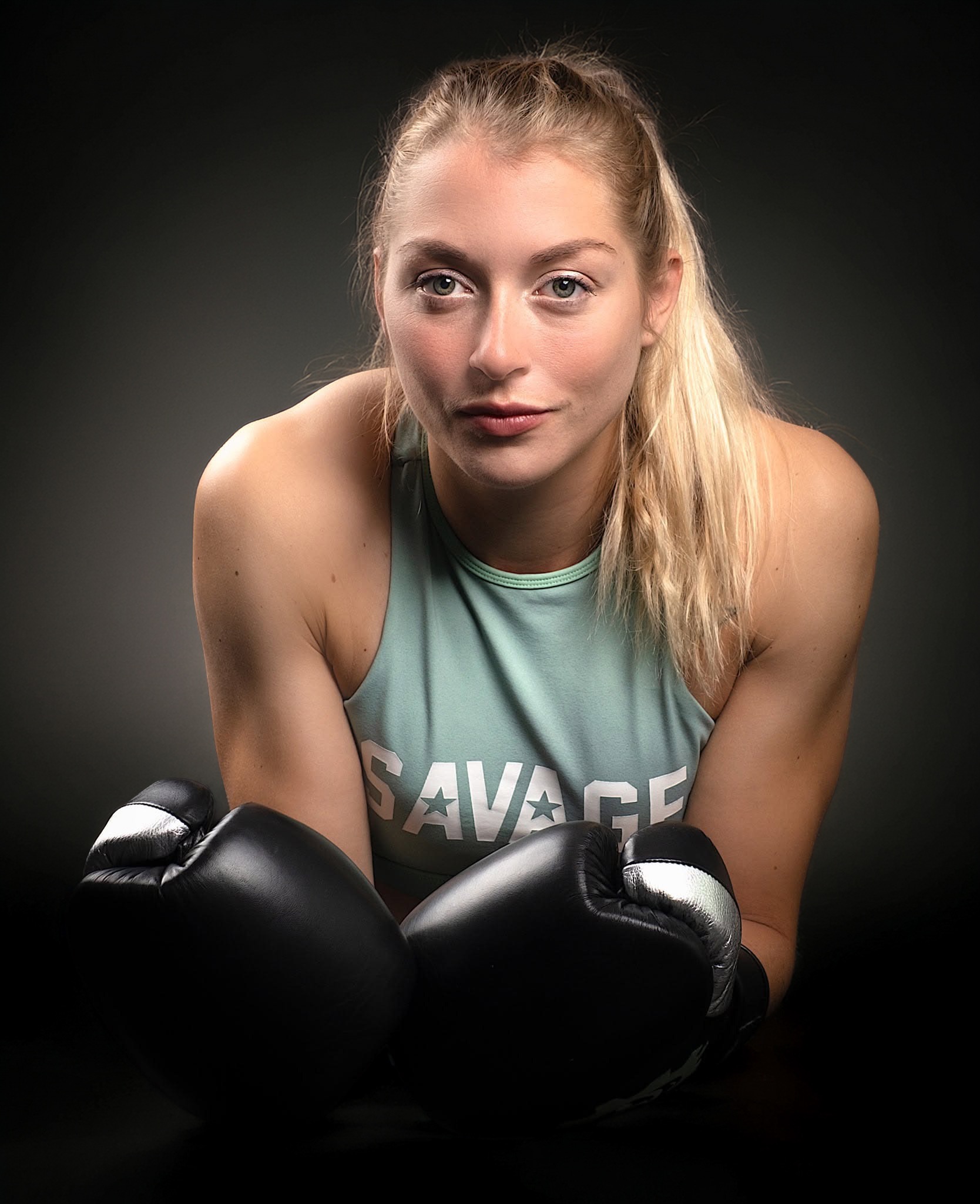 Portrait studio d'une boxeuse, gants au premier plan