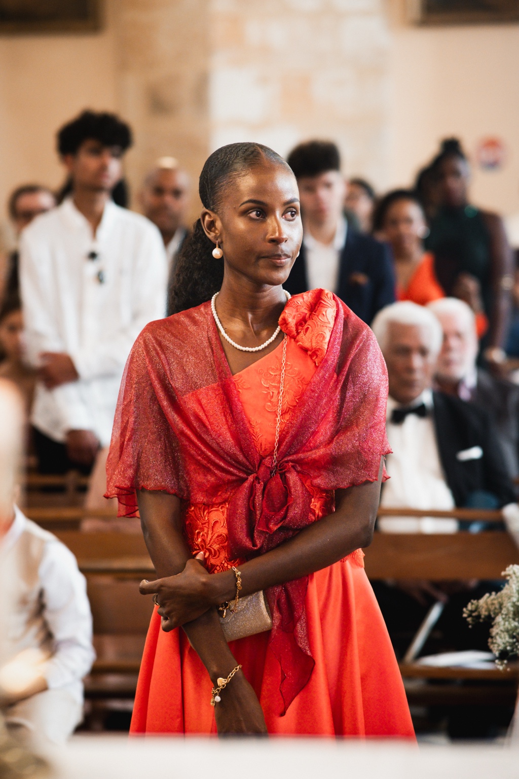 Invitée vêtue de rouge dans la lumière de l’église